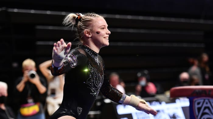 Jade Carey smiles after completing a routine during an Oregon State gymnastics competition.